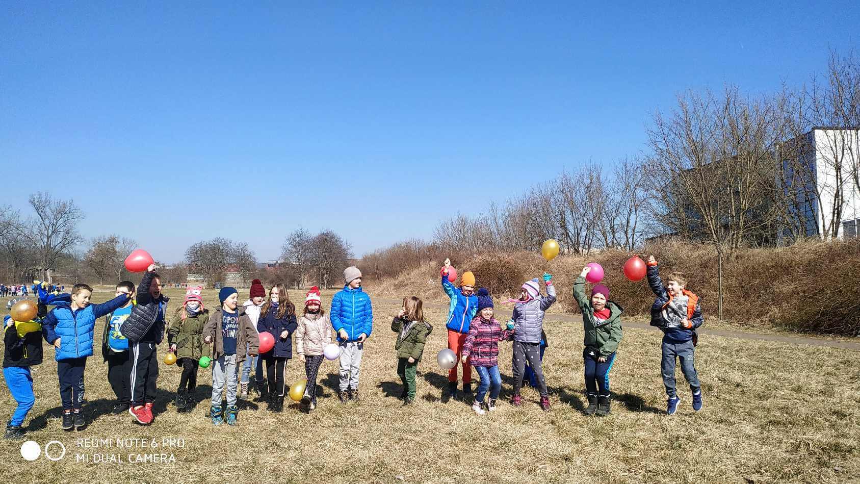 dzieci z balonami na trawie